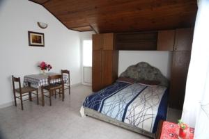 a bedroom with a bed and a dining room with a table at Apartments Roza in Herceg-Novi