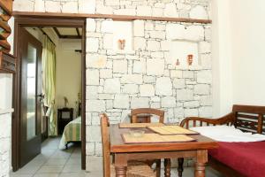 una mesa y sillas en una habitación con una pared de piedra en Villa Andreas, en Gouves