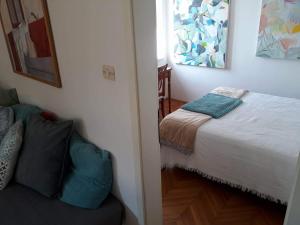 1 dormitorio con cama y sofá en Punta Nana Mira, en Piran