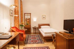 Kleines Zimmer mit einem Bett und einem Schreibtisch mit einem Computer. in der Unterkunft Hotel Kaiserin Elisabeth in Wien