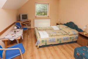 Un dormitorio con dos camas y una mesa y sillas. en Páratlan Apartmanház, en Szilvásvárad