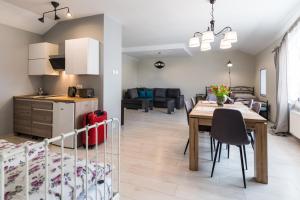a kitchen and living room with a table and a dining room at Lake & City Apartments in Giżycko