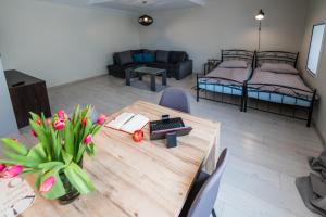 a room with a table and a room with two beds at Lake & City Apartments in Giżycko