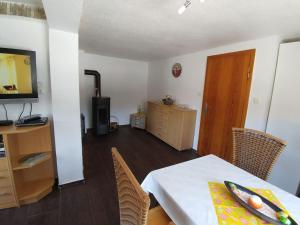a living room with a table and chairs and a television at Holiday Home in Altenfeld with Private Pool in Altenfeld