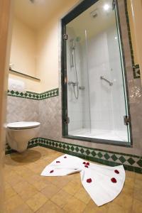 a bathroom with a shower and a white towel with hearts on it at Senator Hotel Tanger in Gzennaïa