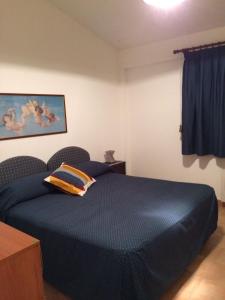 a bedroom with a blue bed with a pillow on it at Residenza Le Serre in Acciaroli