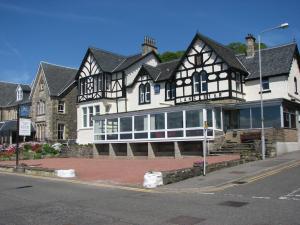 a large black and white house on the corner of a street at Lancaster Hotel in Oban