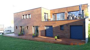 a house with a deck and a person standing in front of it at Chambres d'Hôtes Nature et bois BED AND BREAKFAST in Saint-Germain-sur-Morin