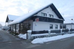 un edificio blanco con nieve en el costado en Guest Accomodation Škerlak en Moravske-Toplice