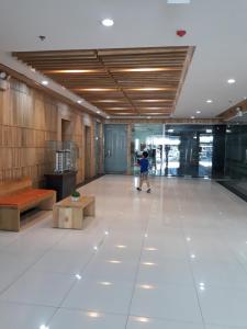 a person walking through a large room with a person standing in a building at YulZ 516 at Cityscape in Bacolod