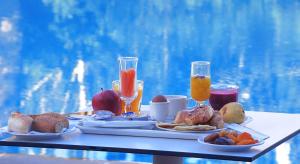 a table with a tray of breakfast foods and drinks at Senator Hotel Tanger in Gzennaïa