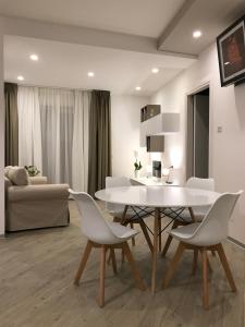 - un salon avec une table et des chaises blanches dans l'établissement A Matera "Sotto i pini", à Matera