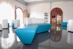 eó Suite Hotel Jardin Dorado في ماسبالوماس: غرفة مع كرسي أزرق في غرفة