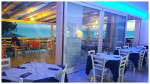 a restaurant with white tables and chairs and glass doors at B&B La Civetta in Agropoli