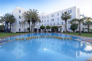 una grande piscina di fronte a un edificio di Senator Hotel Tanger a Gzennaïa