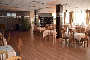 a dining room with white tables and chairs at Балнеохотел "Гергана" in Hisarya