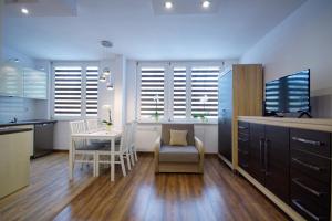 a kitchen and dining room with a table and chairs at Apartament Chełm in Chełm