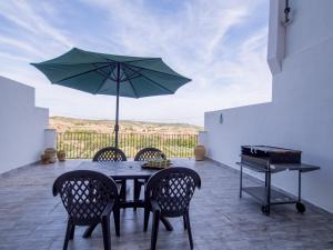 una mesa con sillas y una sombrilla en el patio en Casa Esperanza, en Alborache