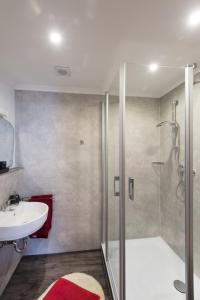 W łazience znajduje się szklana kabina prysznicowa i umywalka. w obiekcie Wein & Gästehaus Ballmann w mieście Trittenheim