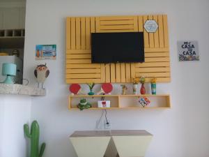 sala de estar con TV en la pared en Recanto da Orla - apartamento lindo e aconchegante - 2 Quartos, en Porto Seguro