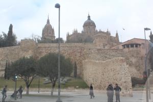 a group of people standing in front of a castle at Puente Romano by Salamancavacacional in Salamanca