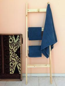 a towel rack with blue towels on a wall at Casa Namaste Bed & Breakfast/Appartement in Praia