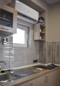 een keuken met een wastafel en een raam bij Apartmani Zrenjanin in Zrenjanin