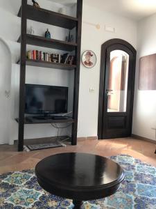 sala de estar con mesa de centro negra y TV en Residenza Le Serre, en Acciaroli