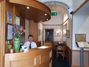 a man sitting at a counter in a restaurant at Welbeck Hotel & Apartments in Douglas