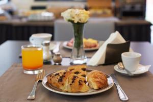a table with a plate of bread and orange juice at Garibaldi Palace in Milan +15 photos