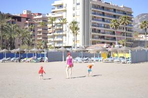 トレモリノスにあるTrianaの海岸を歩く女と子供2人