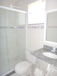 a bathroom with a shower and a toilet and a sink at Estrela Azul Guest House Búzios in Búzios