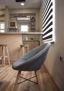 a gray chair in a kitchen with a counter at Apartmani Zrenjanin in Zrenjanin