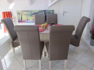 a dining room table and chairs with a bowl of fruit at Ferienwohnungen Lichtblick und Sonneck in Hilpoltstein