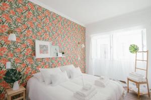 ein Schlafzimmer mit einem Bett mit Blumentapete in der Unterkunft Casas de Mar - Concha in Olhão