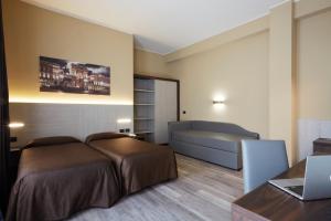 a bedroom with a bed and a desk with a laptop at Garibaldi Palace in Milan