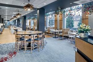 ein Esszimmer mit Tischen, Stühlen und Blumen in der Unterkunft Hotel Aquarion Family & Friends - Destigo Hotels in Zakopane