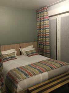ブローニュ・シュル・メールにあるL'appartement de la Matelote face mer 4 personnesのベッドルーム1室(カラフルなカーテン付きのベッド1台付)