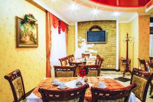 a dining room with tables and chairs and a television at Hotel Sofia in Polyana