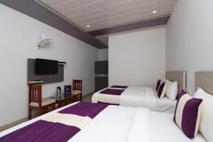 Habitación de hotel con 2 camas y TV en Rock resort en Dhanaulti