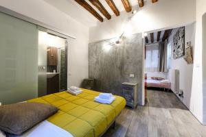 a bedroom with a yellow bed and a fireplace at La Perla in Venice