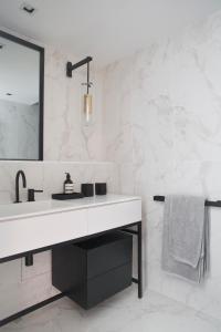 a white bathroom with a sink and a mirror at Le petit M Chamonix au pied du Brévent in Chamonix