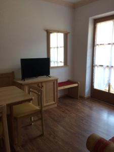uma sala de estar com uma televisão e uma mesa e cadeiras em Biohof Niedereben em Rabla