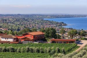 a house on top of a hill next to the water at Agriturismo Ca' Zerbetto in Bardolino