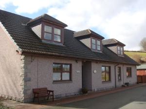 a house with a roof with windows and a bench at Deveron Lodge B&B in Turriff