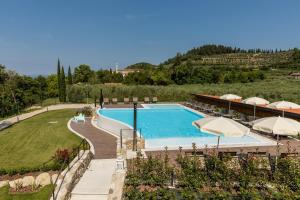 a swimming pool with umbrellas and a resort at Agriturismo Ca' Zerbetto in Bardolino