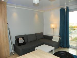 a living room with a couch and a window at Sunny Apartment I in Koszalin
