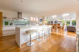 a kitchen with a large island with bar stools at Swiss Cottage in Aldringham