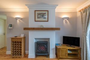 a living room with a fireplace and a tv at The Nook County Dublin in Dublin