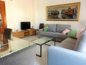 uma sala de estar com um sofá e uma televisão em La Casa De La Tia em Málaga